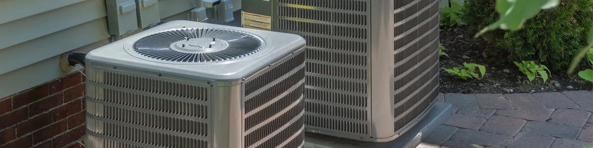 Residential air conditioning units installed beside a home